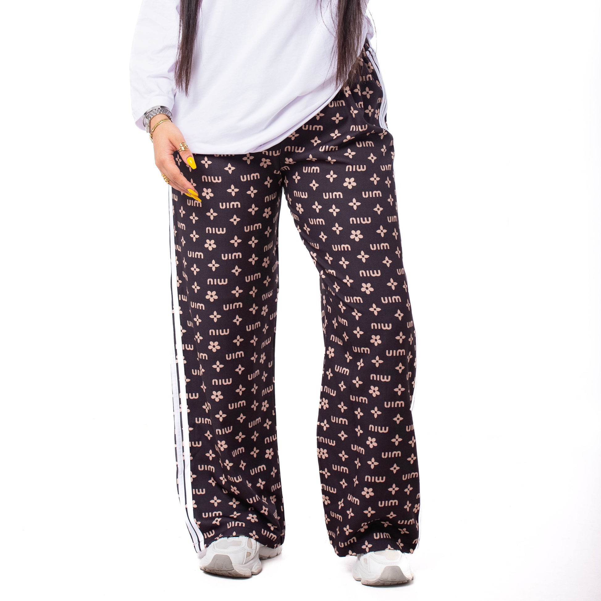 Woman wearing a white sweatshirt and black patterned pants on a white background