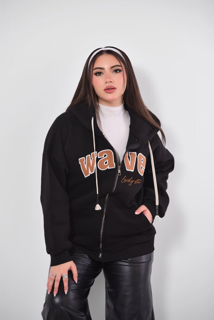 Woman wearing a black hoodie with 'wave' text on a white background