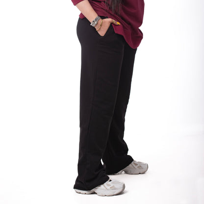 Person wearing a burgundy sweatshirt and black pants on a white background