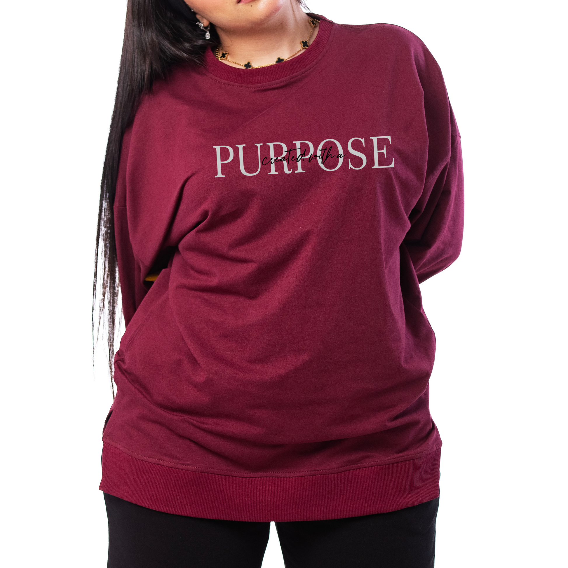 Woman wearing a maroon sweatshirt with 'PURPOSE' text on a white background